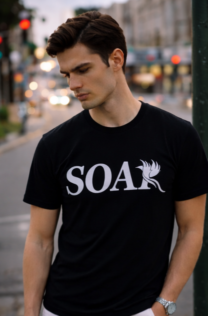 Men’s black SOAR logo t-shirt styled in urban city setting, luxury streetwear aesthetic with white phoenix graphic.