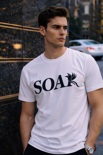 Male model wearing SOAR white luxury streetwear t-shirt with black phoenix logo in urban city setting